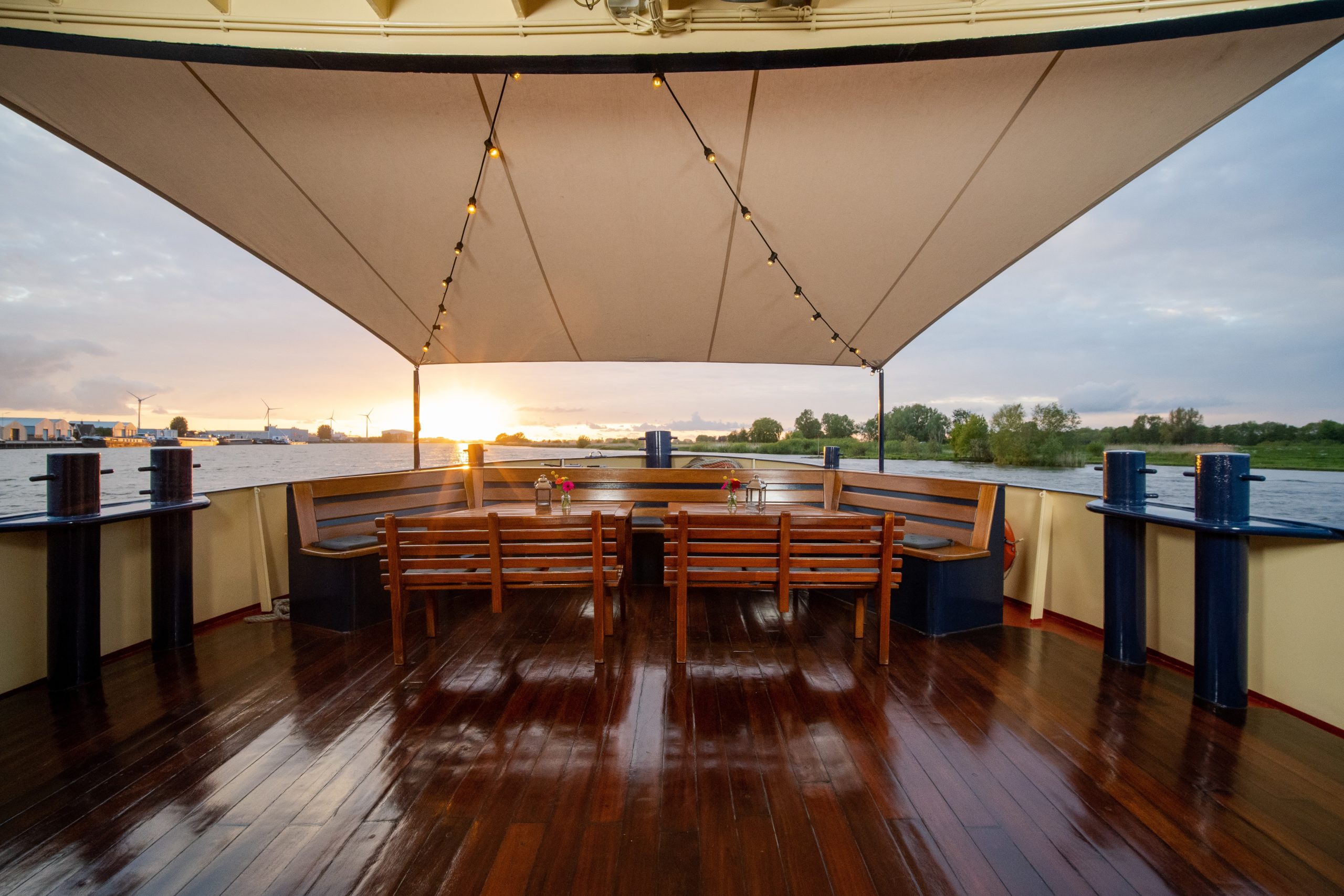 wooden chairs tables with flowers lanterns top boat scaled